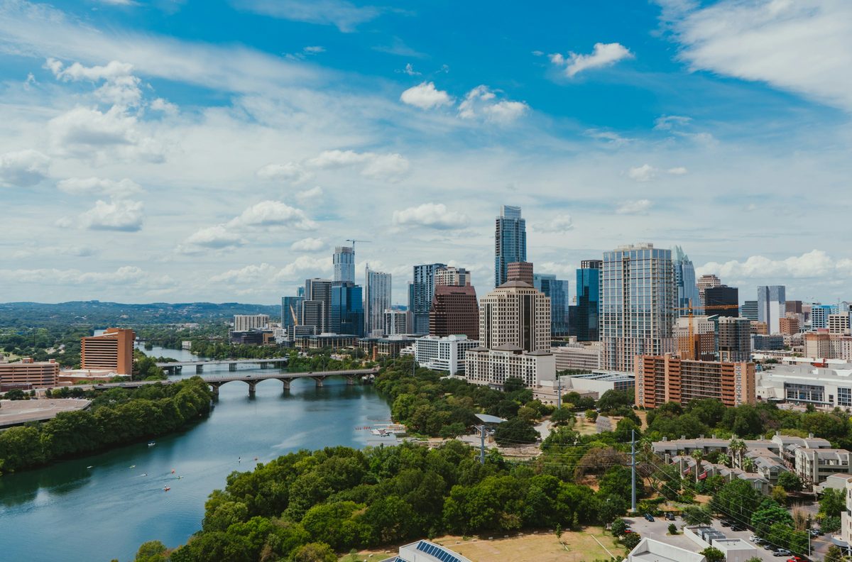 Downtown Austin on a clear day, viewed across Lady Bird Lake with kayaks on the water